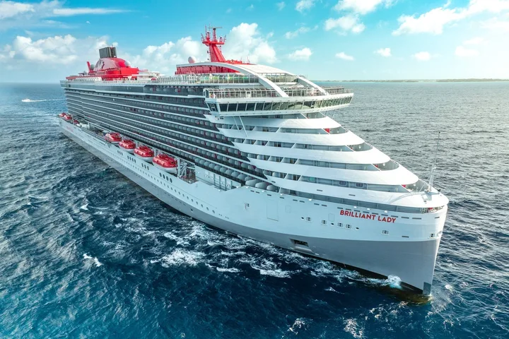 Virgin Voyages cruise ship named Brilliant Lady sailing on open blue ocean.