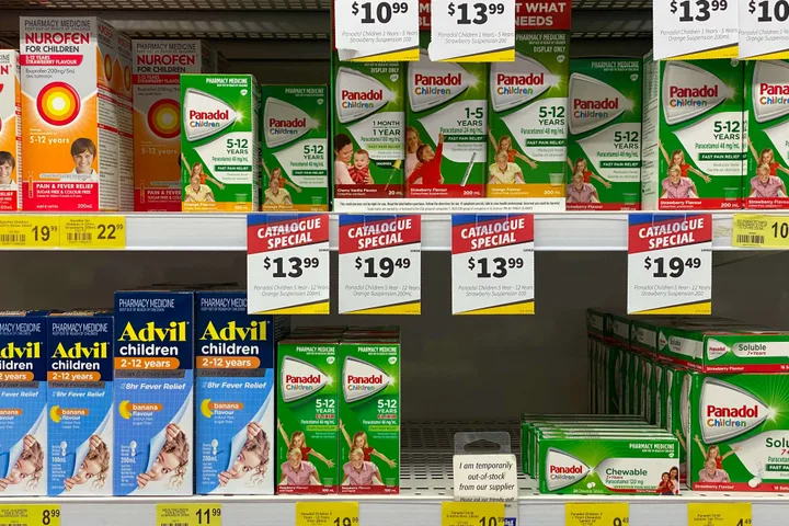 Pharmacy shelf displaying children's medicine brands with price tags and catalogue special signs.
